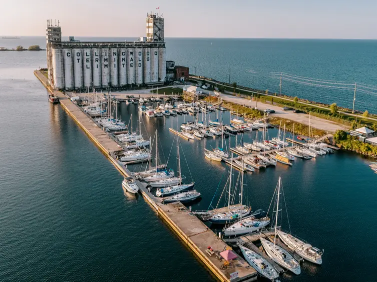 Vista aérea del puerto de Collingwood con las históricas terminales de granos, veleros atracados en un puerto deportivo y la Bahía Georgiana extendiéndose hacia el horizonte.