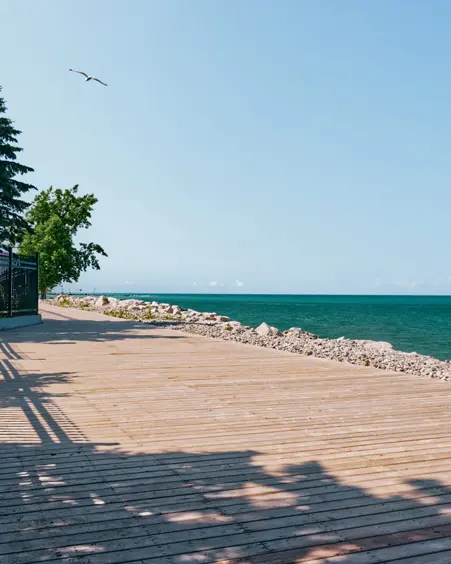 Promenade in Goderich, Ontario, entlang des türkisfarbenen Wassers des Lake Huron unter einem strahlend blauen Himmel.