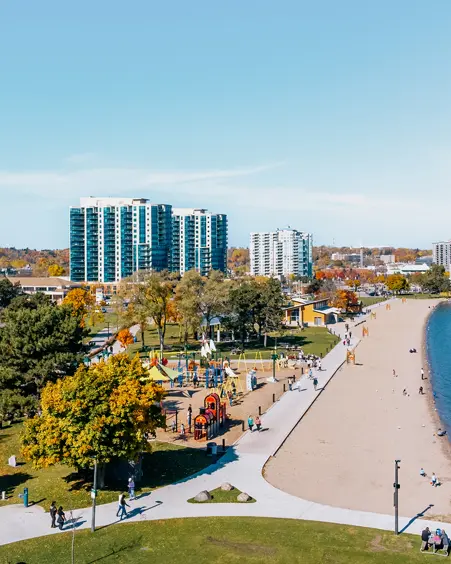 Aerial view of Centennial Park and Beach in Barrie, with a playground, walking paths, and a sandy shoreline along Kempenfelt Bay