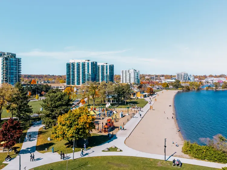  Vista aérea del parque y la playa Centennial en Barrie, con un área de juegos infantiles, senderos para caminar y una costa de arena a lo largo de la bahía de Kempenfelt.