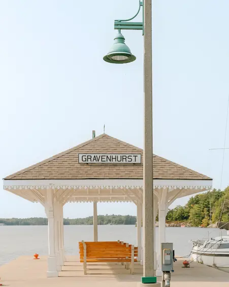 Un quai couvert sur le lac Muskoka, auquel un voilier est amarré, par une belle journée d’été.