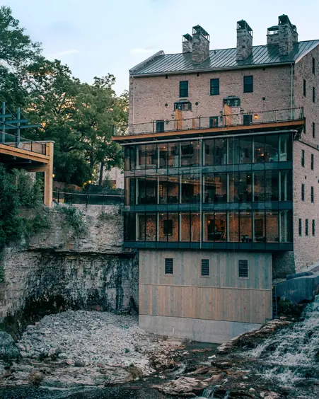 Die historische Elora Mill aus Stein mit einem modernen Glasanbau thront über der Elora-Schlucht und bietet Aussicht auf die felsigen Klippen und das herabstürzende Wasser.