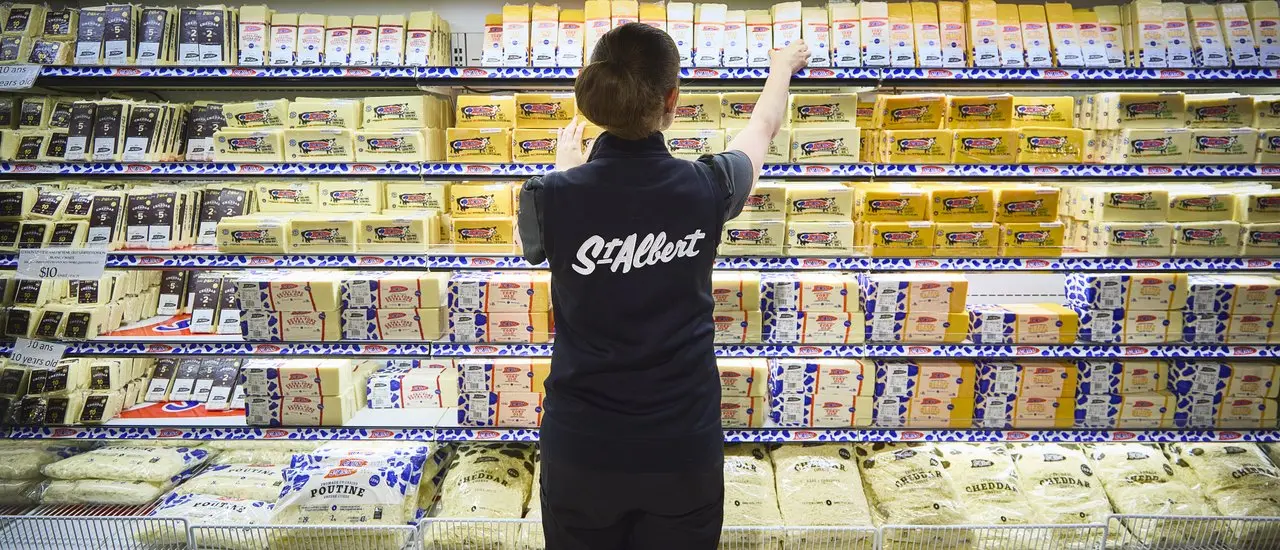 Eine Frau bietet im St-Albert Cheese Shop in der Nähe von Ottawa verschiedene Käsesorten an.
