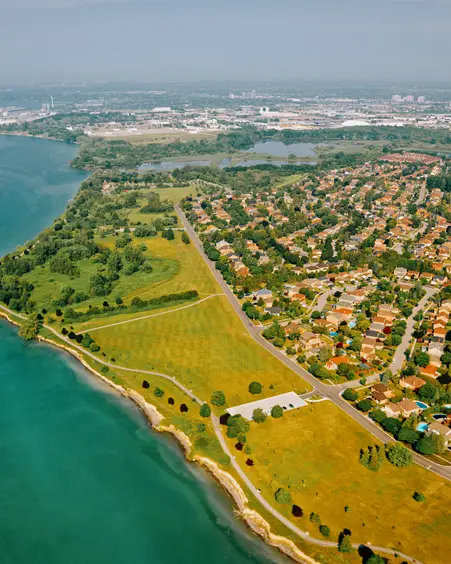 Vista aérea del Parque de la Ribera de Ajax a lo largo del Lago Ontario en un soleado día de verano, mostrando espacios verdes, senderos para caminar y áreas residenciales cercanas.