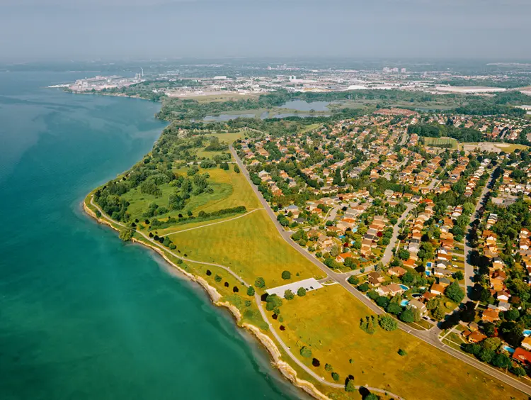 Luftaufnahme des Ajax Waterfront Park am Ontariosee an einem sonnigen Sommertag, der Grünflächen, Wanderwege und nahegelegene Wohngebiete zeigt.
