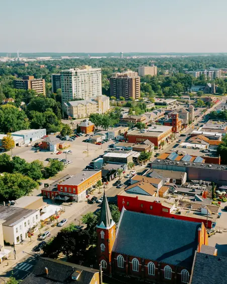 Vue aérienne du centre-ville de Milton et de ses bâtiments historiques, ses rues bordées d’arbres et ses propriétés résidentielles.