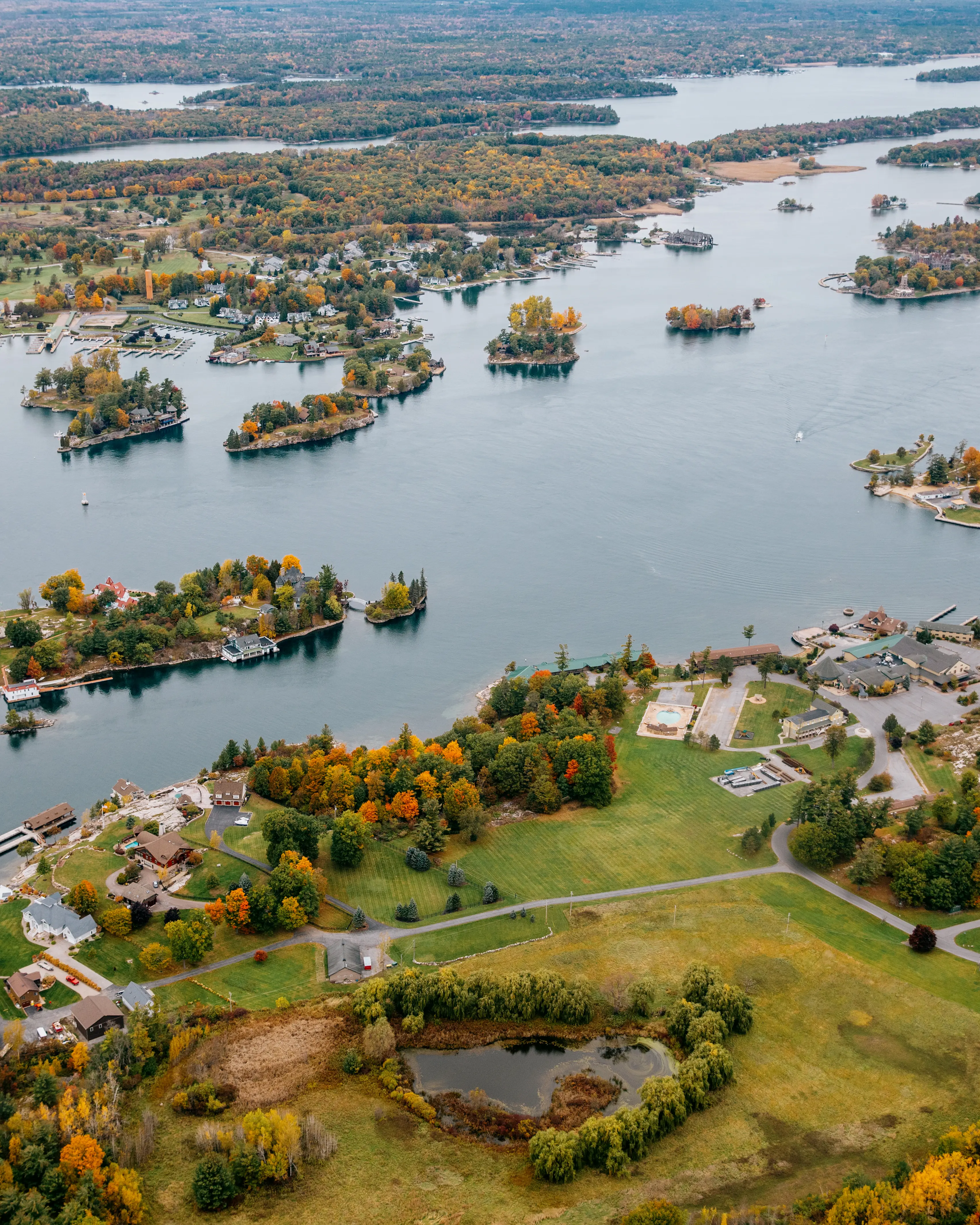Luftaufnahme der Thousand Islands-Region mit ihren kleinen bewaldeten Inseln und Küstenhäusern an einem bewölkten Herbsttag.
