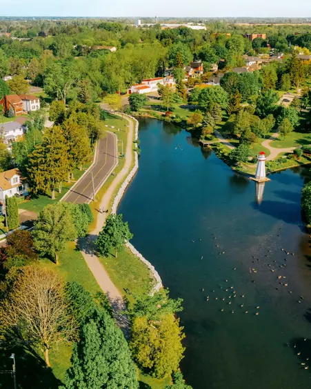 Comté de Norfolk Vue aérienne du parc Wellington, à Simcoe, montrant une rivière sinueuse, des arbres verts et une structure de style de phare dans l’eau.