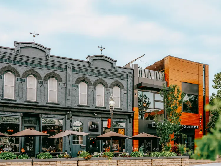 Paysage de rue du centre-ville historique de Kingsville, avec des façades de magasins patrimoniales et des feuillus, un jour d’été ensoleillé.