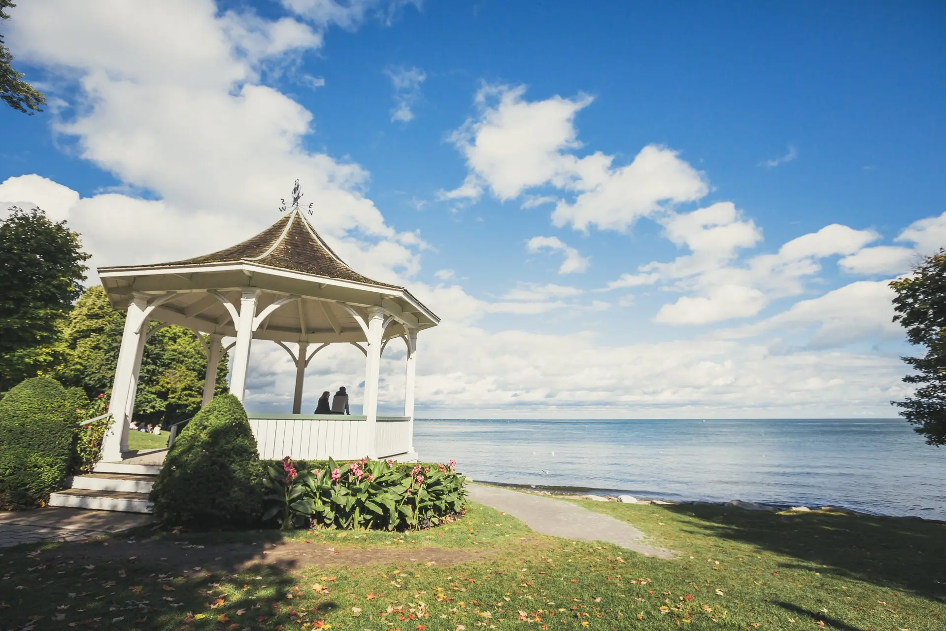 Deux personnes dans un belvédère blanc dans le parc Queen's Royal à Niagara-on-the-Lake regardant la rivière Niagara.