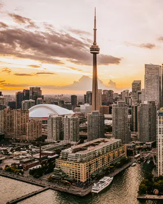 Blick auf die Stadtlandschaft von Toronto vom Hafen aus mit dem CN Tower und der Innenstadt vor einem dramatischen Himmel.