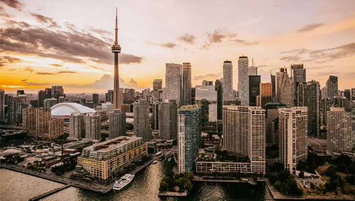 ドラマチックな空を背景に CN タワーとダウンタウンがそびえ立つ、港から見たトロントの街並み。