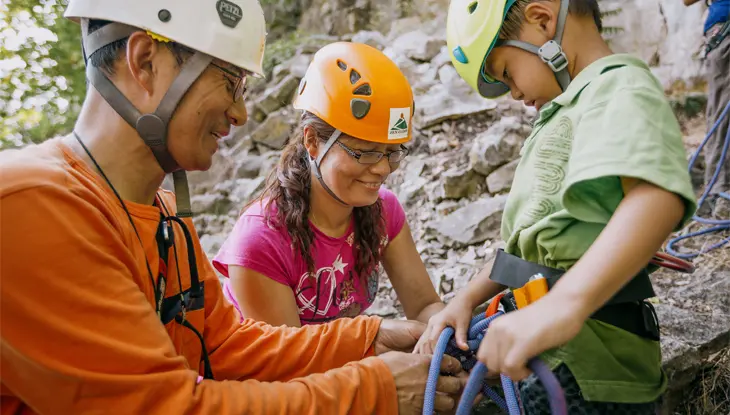 Actividad de escalada en roca en el área de conservación de Rattlesnake Point en Milton, Ontario, con una familia con cascos y arneses.