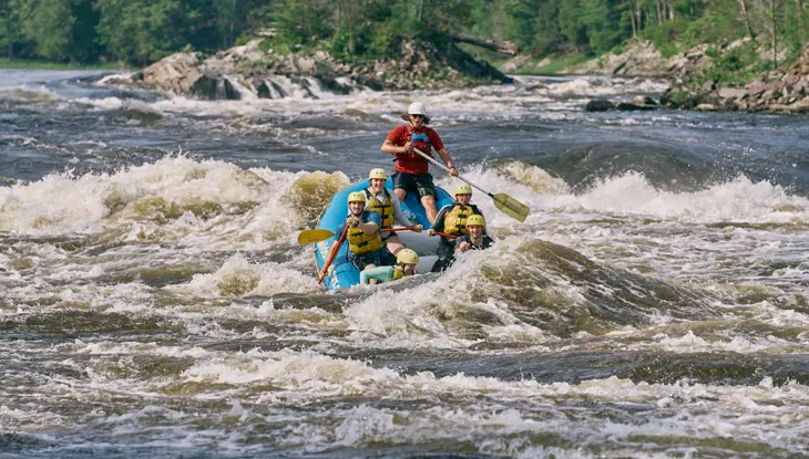 Un grupo de personas haciendo rafting en el río Ottawa con guías de Wilderness Tours.