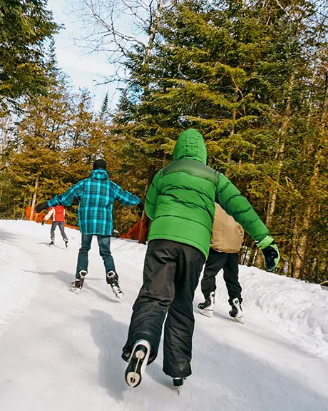 Children race along the snowy ice trail through the forest.