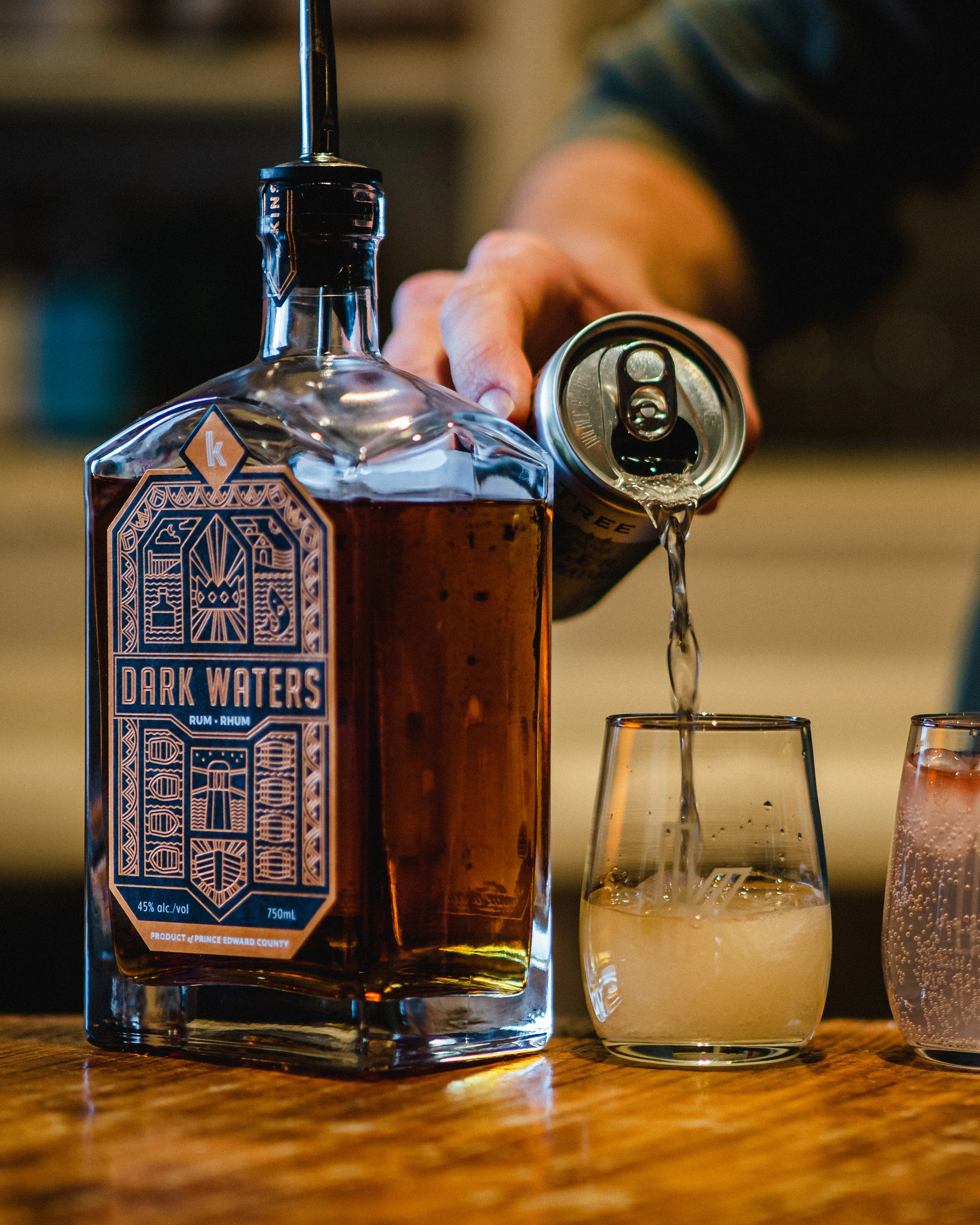 Un homme verse des spiritueux de qualité dans un verre chez Kinsip House of Fine Spirits.