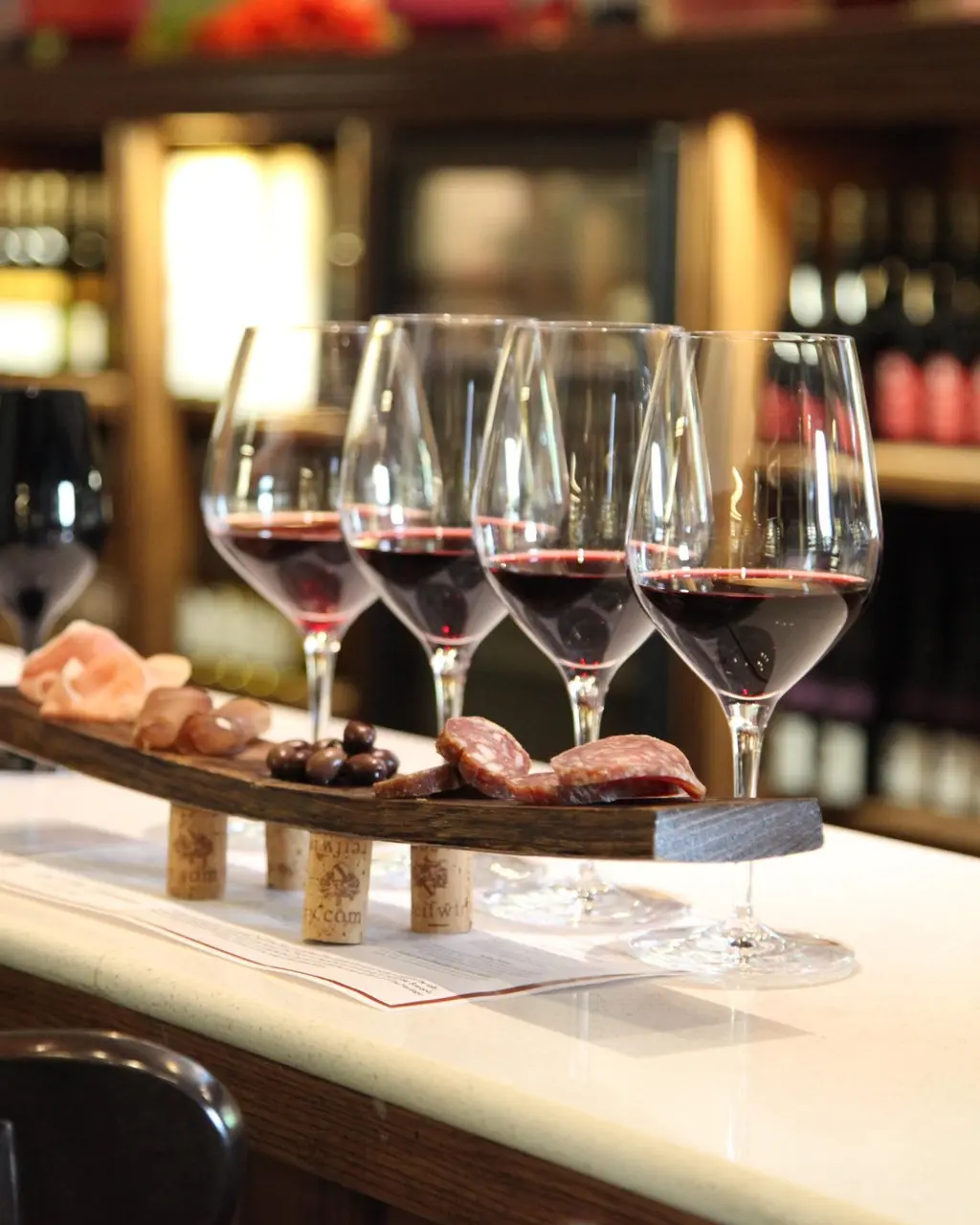 A wine and charcuterie pairing flight at Reif Estate Winery in Niagara-on-the-Lake, with red wine glasses and cured meats arranged on a barrel-stave board
