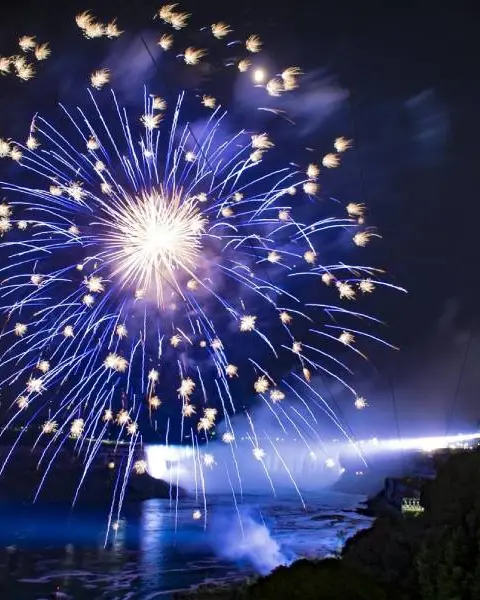 Des feux d'artifice illuminent le ciel au-dessus des chutes du Niagara.