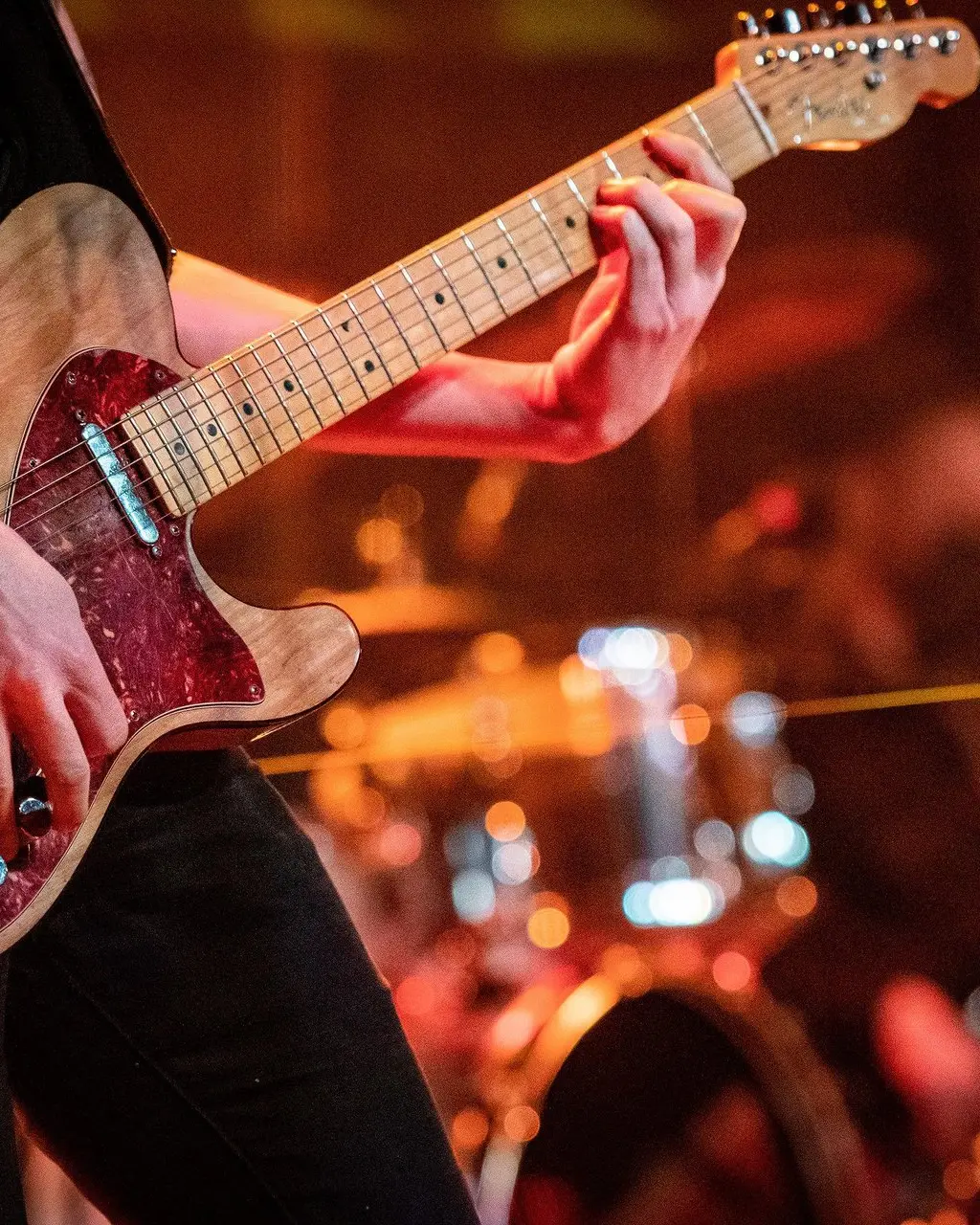 A guitarist playing in the London Music Hall.