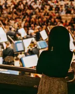 Two audience members are watching the orchestra.