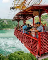 Groupe de personnes traversant les chutes à bord d’un ancien téléphérique.