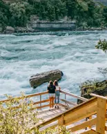 Deux personnes sur le sentier White Water Walk contemplant les rapides déchaînés.