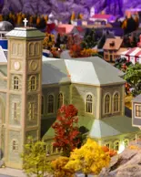A miniature Canadian town which includes green, red, blue and yellow buildings and trees.