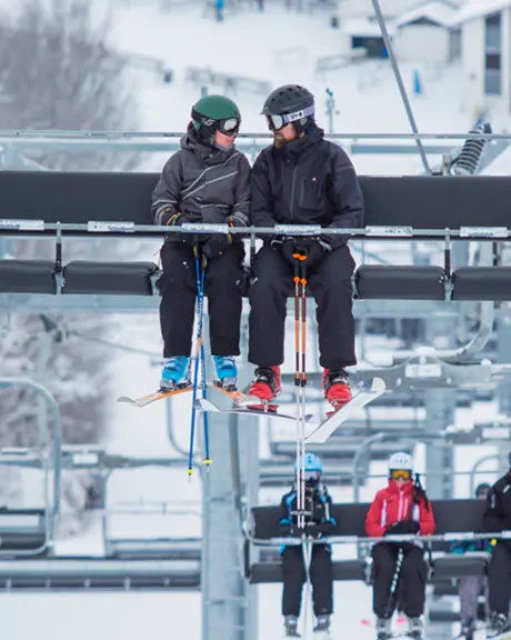 Mehrere Skifahrer fahren mit dem Skilift im Skigebiet Mount St. Louis Moonstone.