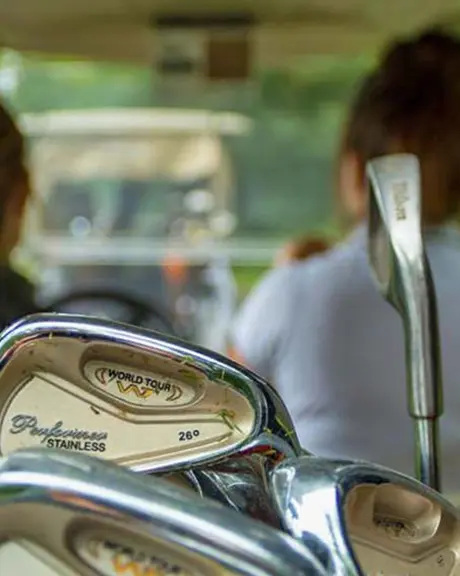 Two woman drive a golf cart across an Ontario golf course.
