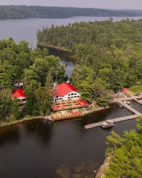 Luftaufnahme einer abgelegenen, nur mit dem Boot erreichbaren Anglerlodge im Norden Ontarios, umgeben von Wasser und Wald.