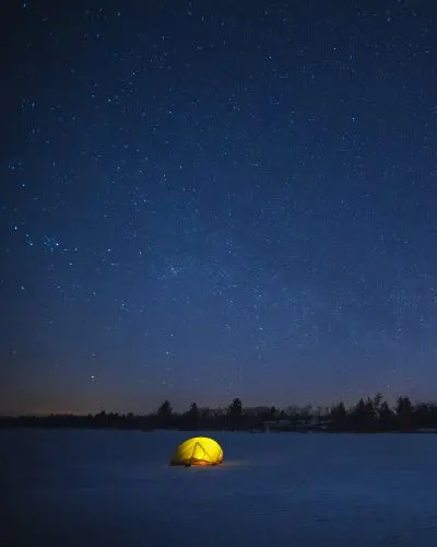 夜、星空の下で光るテント。