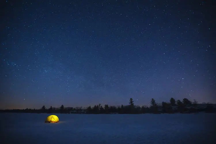 夜、星空の下で光るテント。