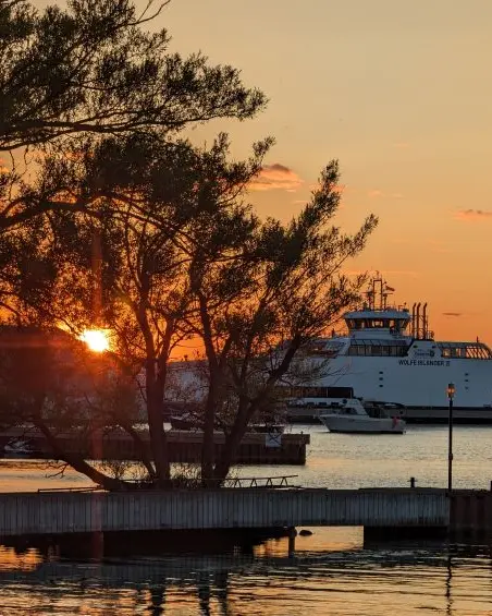 Ein Boot auf dem Wasser bei Sonnenuntergang.