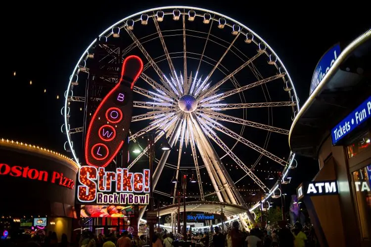 Ein Riesenrad mit Lichtern bei Nacht. 
