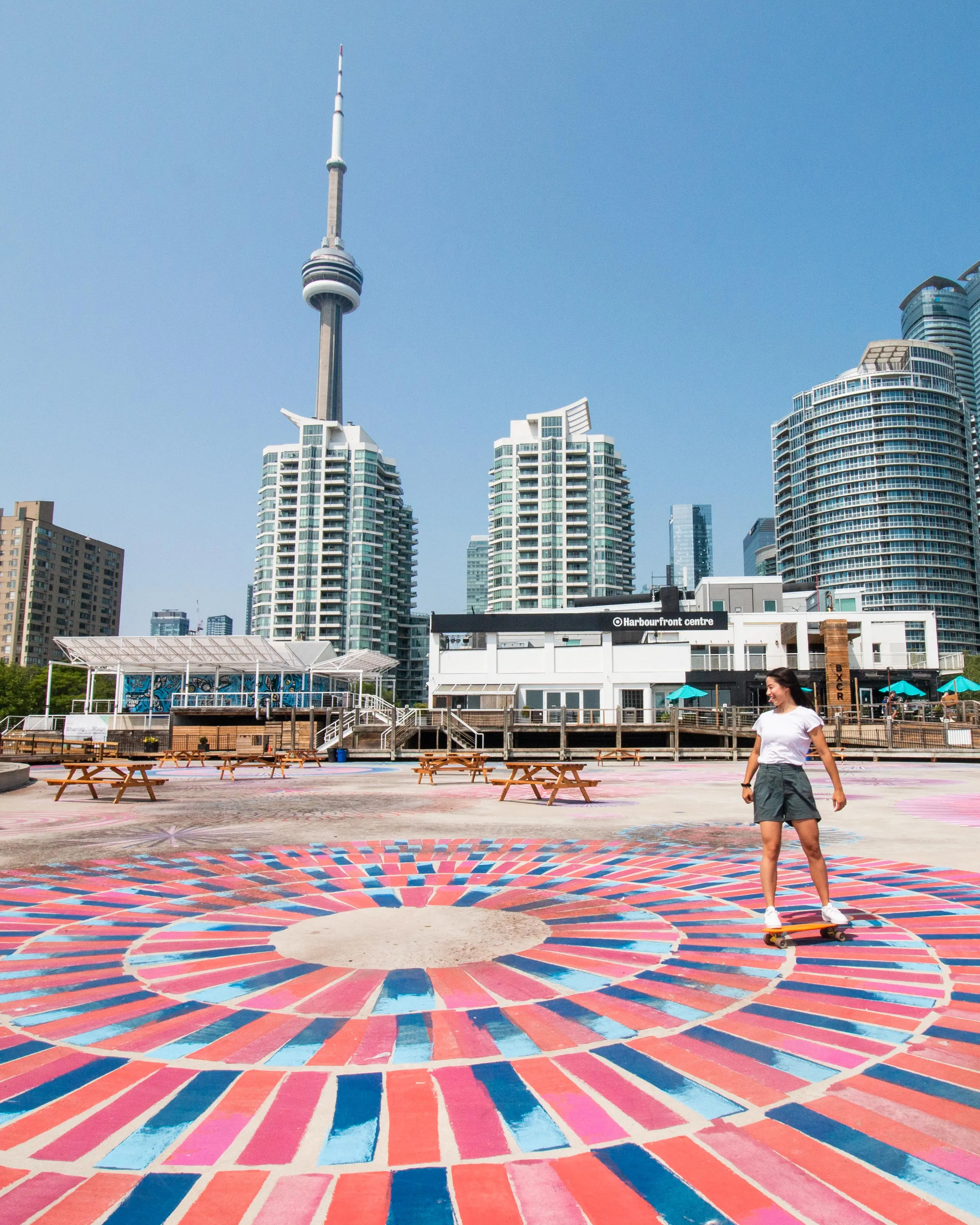 ハーバーフロントセンターの前のカラフルな歩道でスケートボードをする人。 