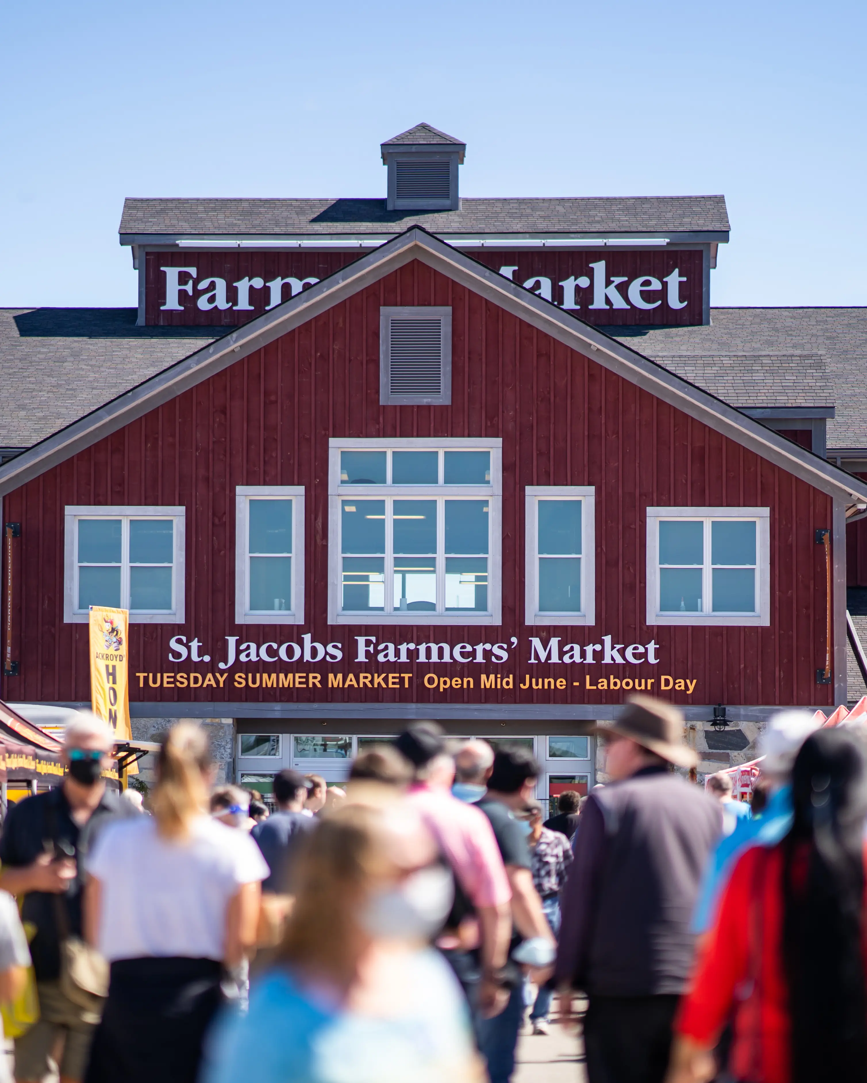 Une foule parcourt le marché de producteurs de St. Jacobs au cours de la journée.