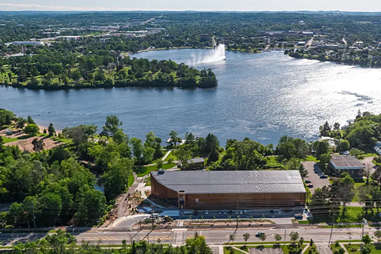 Bird’s eye view of the canoe museum in front of a lake.