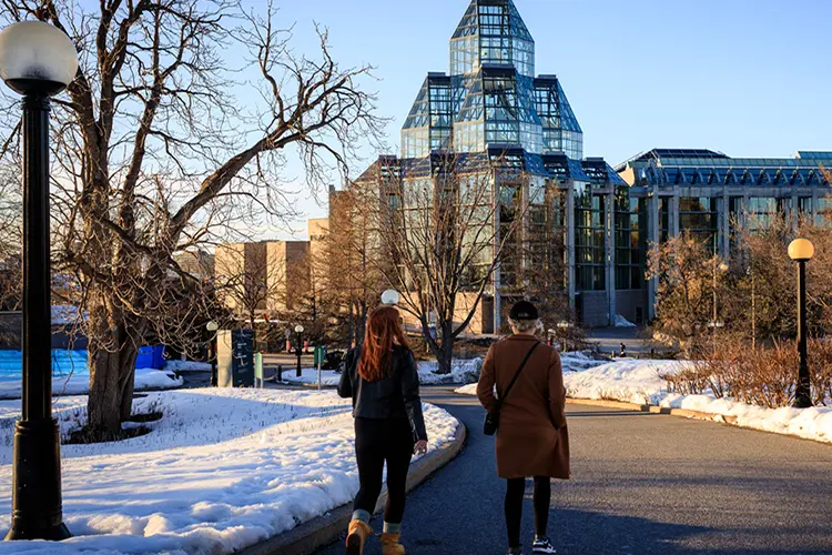 冬、2人の女性がカナダ国立美術館に向かって歩いています。