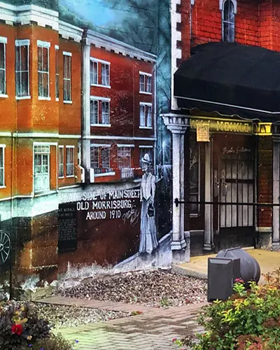 A mural decorates the wall outside of a small town theatre.