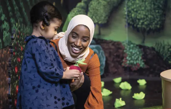 Une jeune fille montrant un jouet à une femme