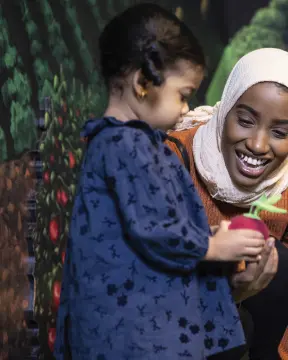 여자에게 장난감을 보여주는 아이