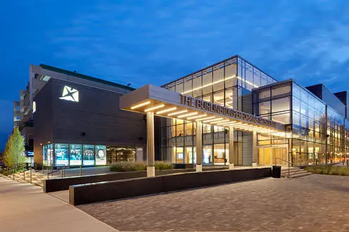 버링턴 공연예술센터 정문. 이 대형 건물에는 바닥부터 천장까지 닿는 여러 개의 창문과 돌담이 있습니다.