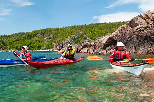 Tres personas en kayaks remando en el agua