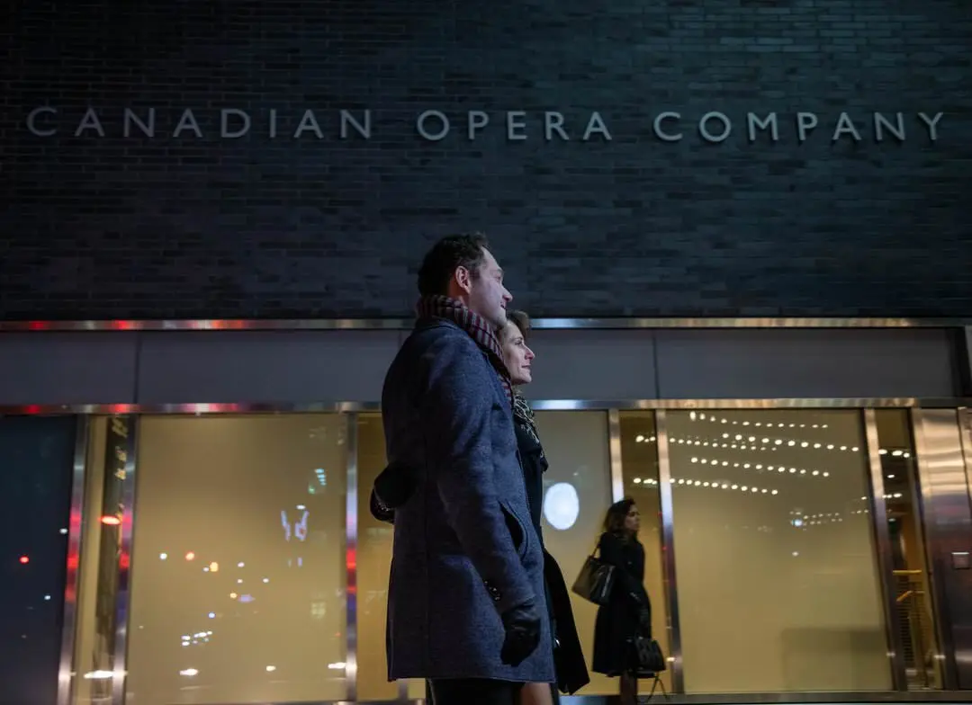 Ein Paar, das vor dem Four Seasons Center spazieren geht