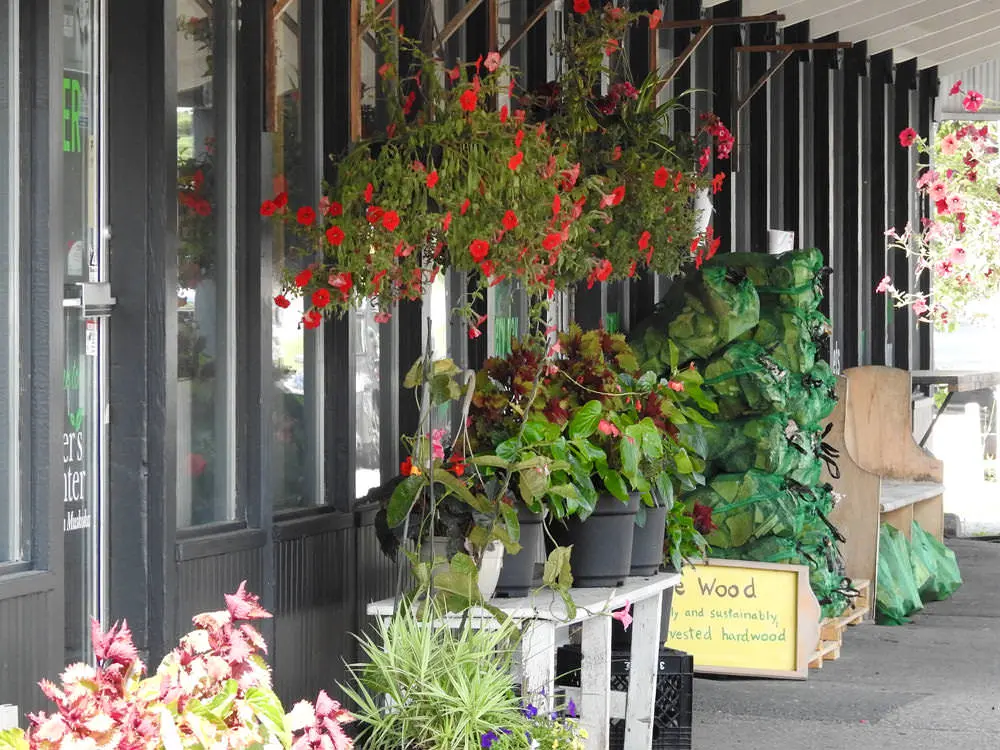 Blumenkörbe schmücken die Außenseite eines Boutique-Lebensmittelgeschäfts