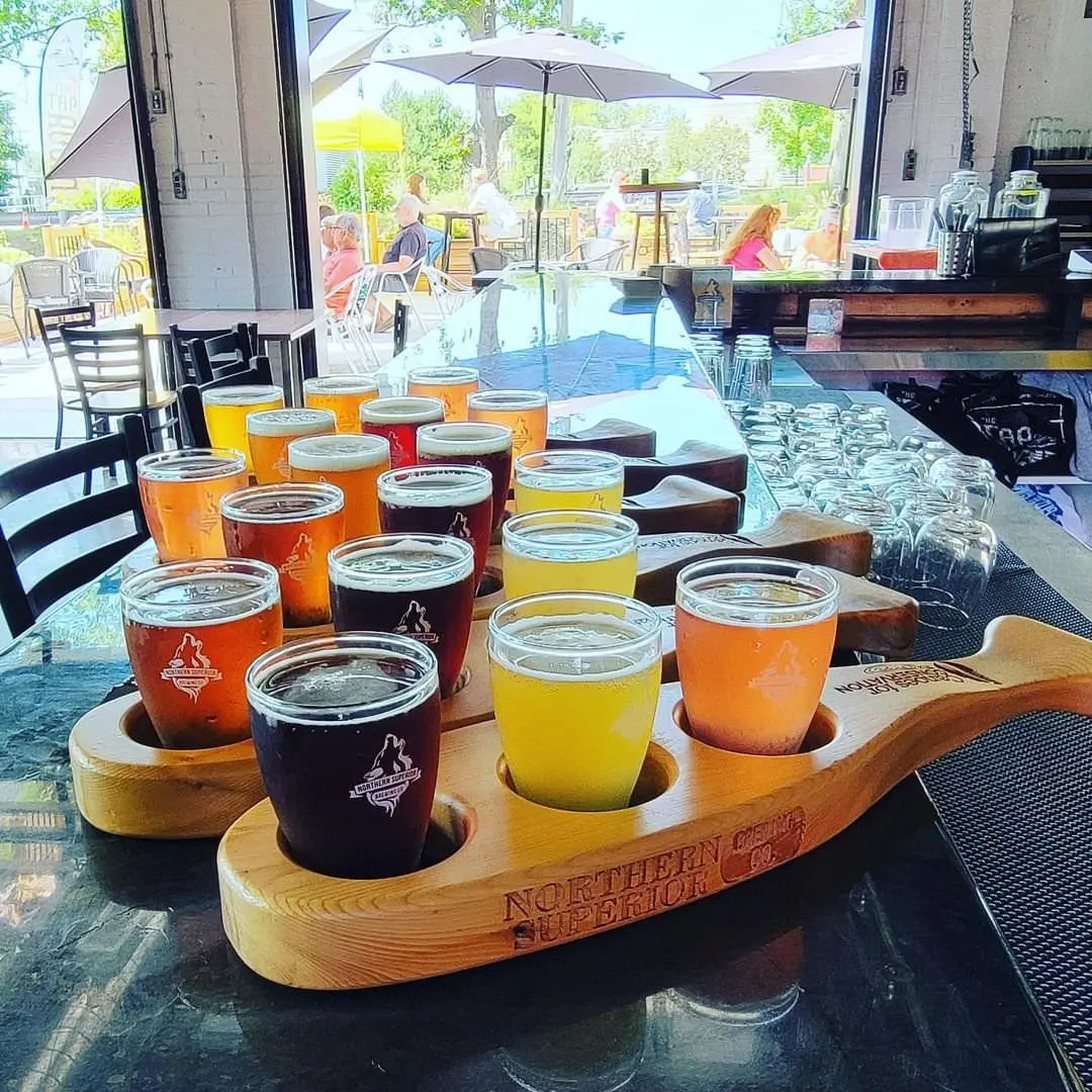 Multiple flights of beer of various colours resting on trays that are whale shaped