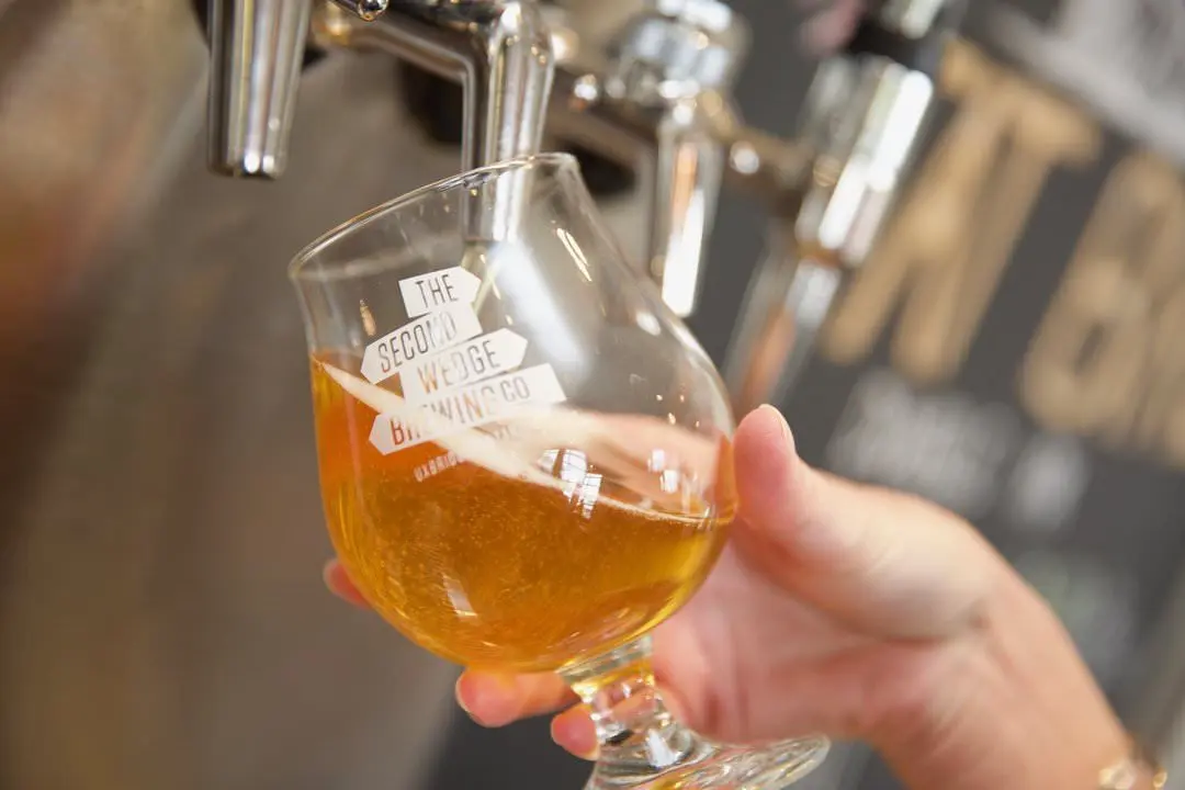 A glass of beer being poured from a beer tap