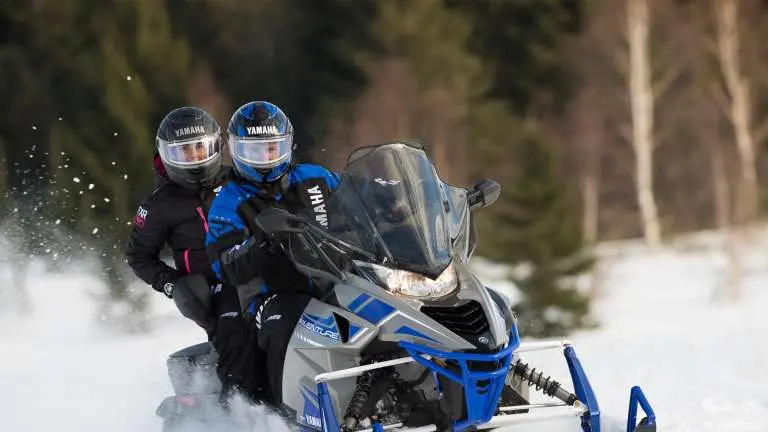 2 people riding a snowmobile