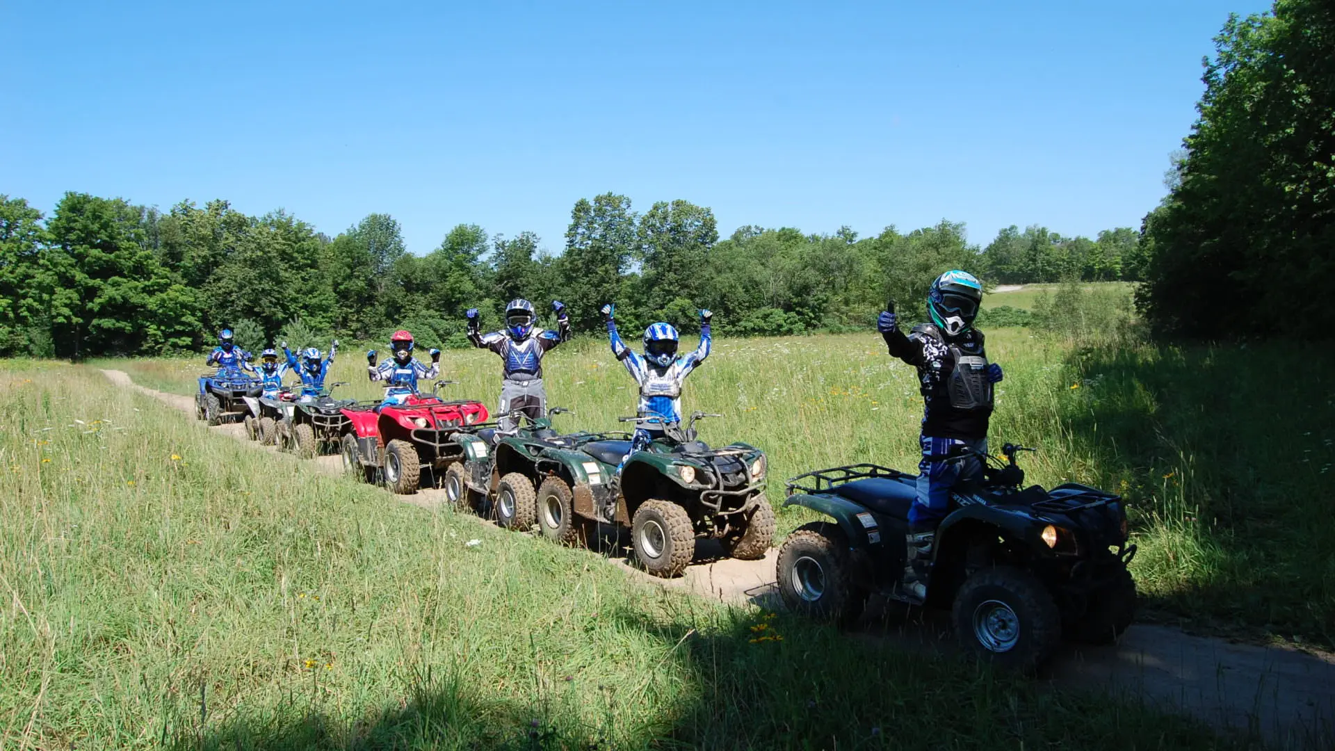 7 ATV riders on a trail pose for a picture