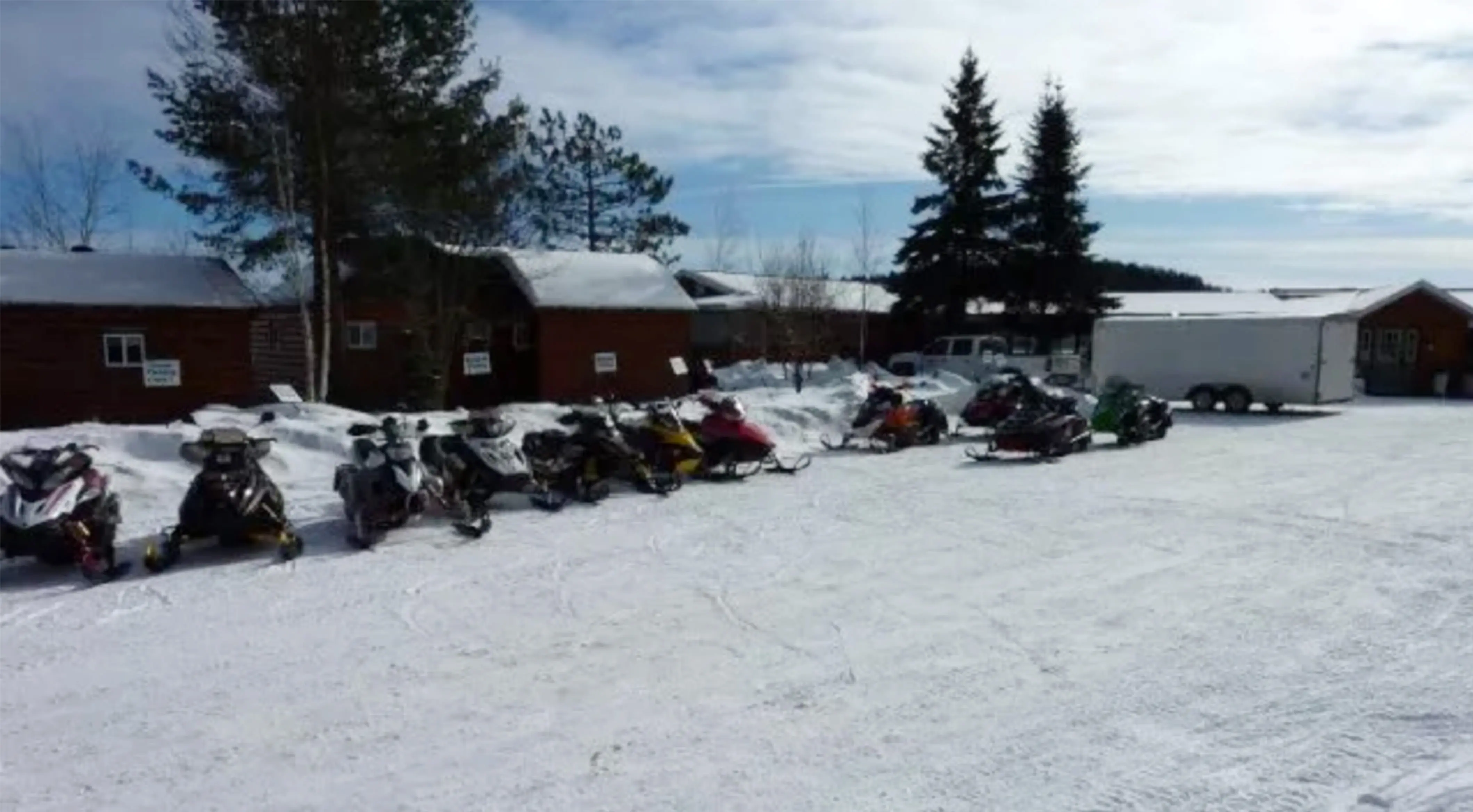 A row of snowmobiles parked in front of buildings